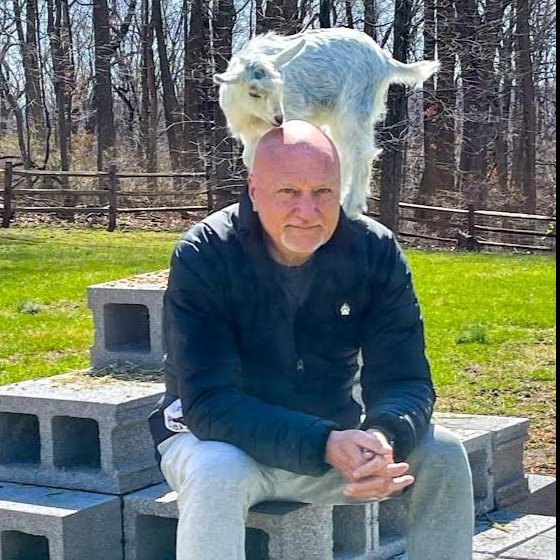Michael sitting with a goat on his back